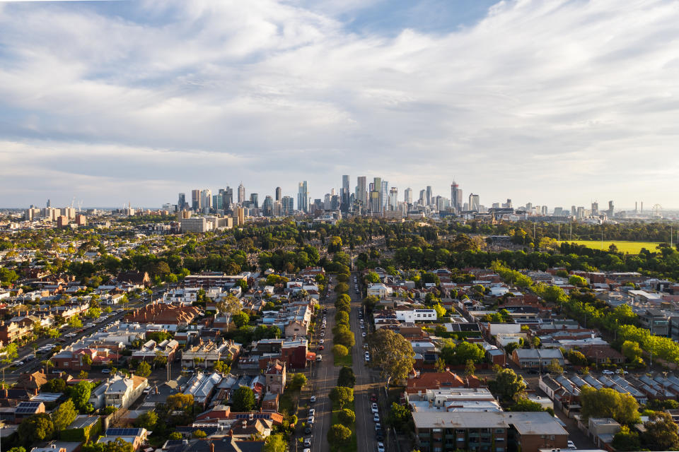 Aerial of Melbourne CBD skyline with suburban Melbourne residential area in the foreground.