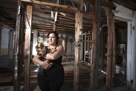 Christine Cina poses for a portrait in what is left of her house after Superstorm Sandy in the Staten Island borough of New York, September 20, 2013. REUTERS/Carlo Allegri