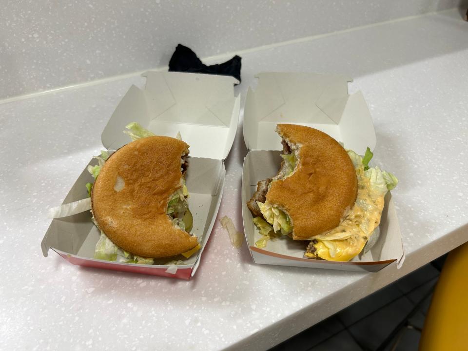 Two half-eaten Big Macs side by side. The fillings have slid out of the new version.