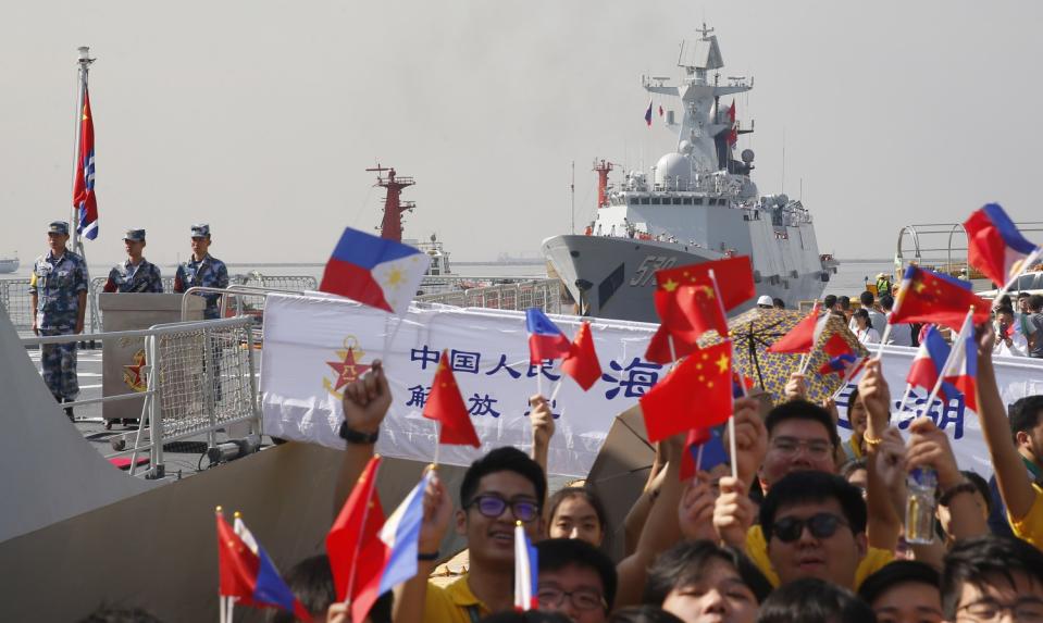 Students wave Philippine and Chinese flags during a visit by Handan, a Chinese guided missile frigate, to the port of Manila in January 2019.