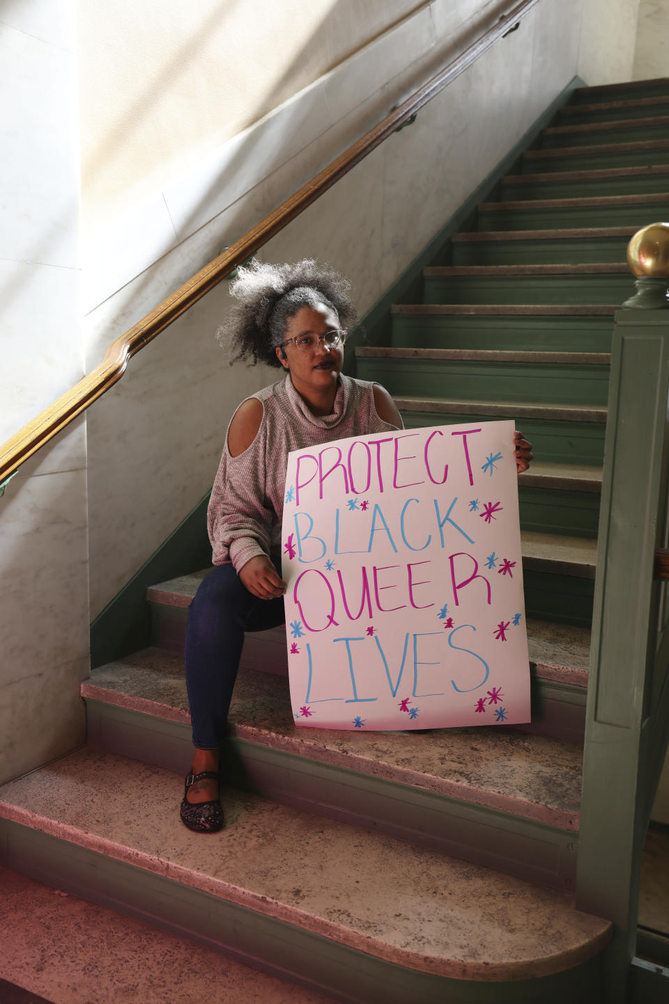 Jacinta Johnson, from Charleston, holds a sign protesting HB 2007, which would ban health care for children, at the state capitol in Charleston, W.Va., on March 9, 2023. (AP Photo/Chris Jackson)