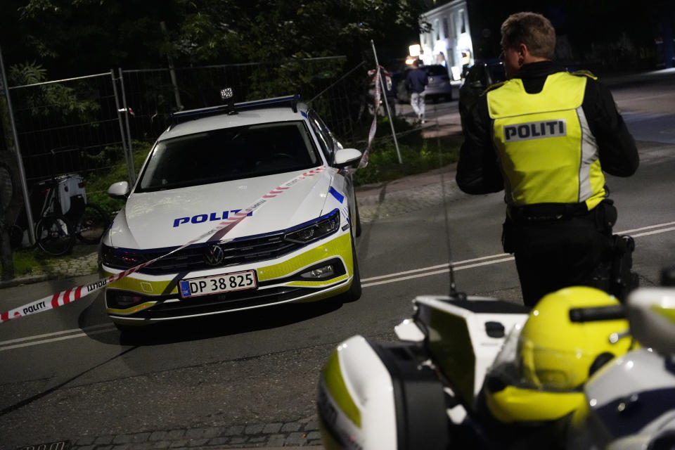 Police stand guard in the Freetown Christiania neighborhood of Copenhagen, Denmark, Saturday, Aug. 26, 2023. Police said two masked gunmen opened fire inside a building in the neighborhood, known for its counterculture vibe and flourishing hashish trade. (Emil Helms/Ritzau Scanpix via AP)