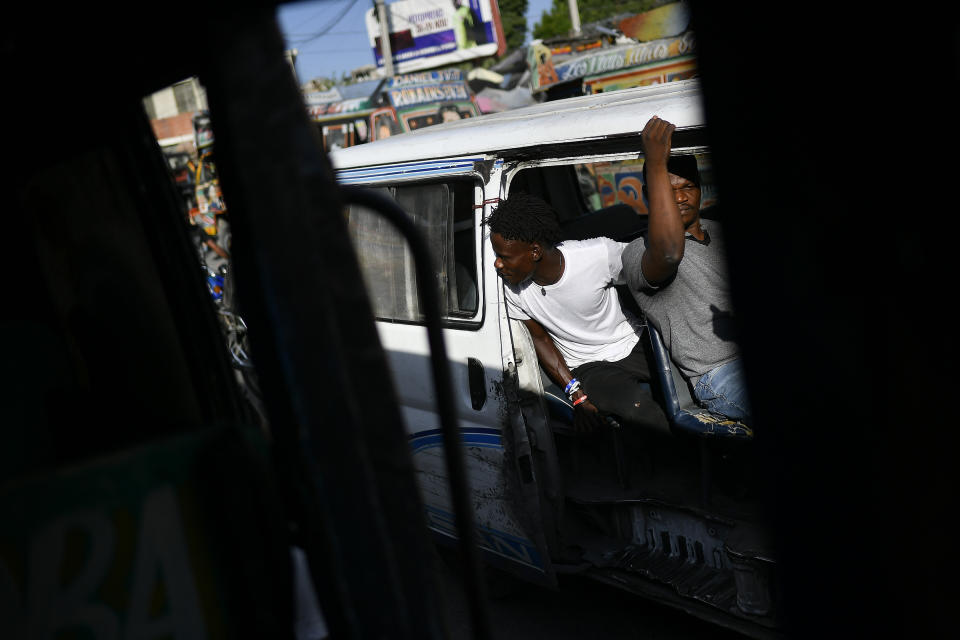 An employee waits for customers to board a bus in Port-au-Prince, Haiti, Saturday, July 10, 2021, three days after President Jovenel Moise was assassinated in his home. (AP Photo/Matias Delacroix)