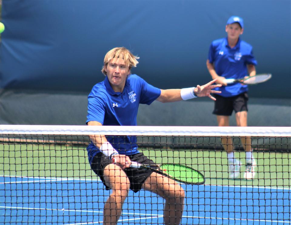 Los compañeros de equipo de St. Xavier, el estudiante de primer año Carson Dwyer (al fondo) y el estudiante de último año Drew Evans, ganaron un campeonato estatal DI el viernes.