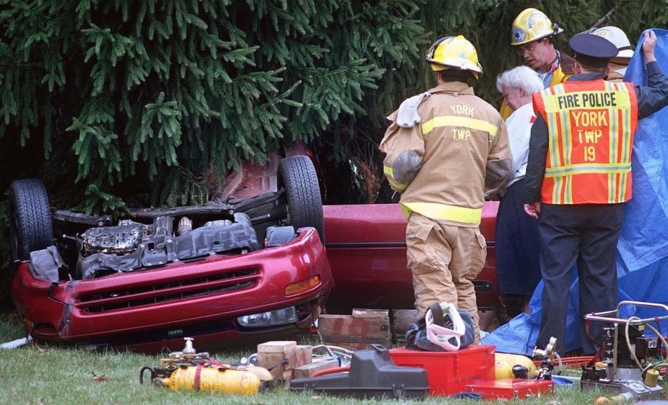 In this 1997 file photo, York County coroner Katheryn Fourhman, surrounded by fire personnel, investigates the scene of a double fatal accident in York Township.