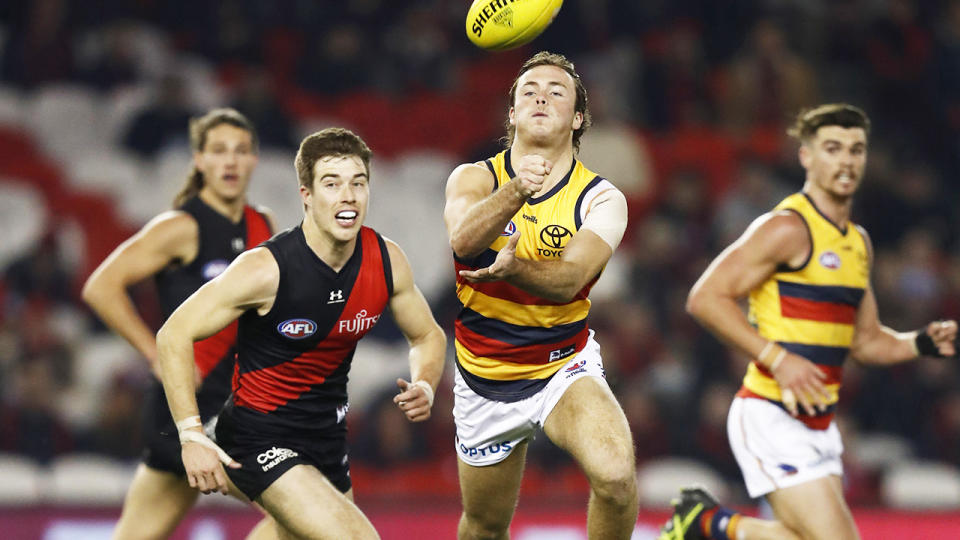 Luke Pedlar, pictured here handballing during the Adelaide Crows' clash with Essendon Bombers.