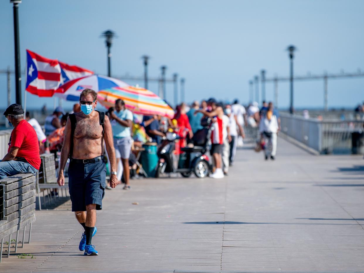 People walking along the boardwalk in Coney Island, New York.