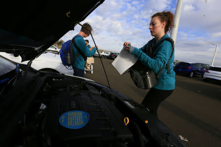 Greenpeace volunteers stand next to a Volkswagen vehicle after gaining access to the vehicle park at the port of Sheerness, Britain, September 21, 2017. Jiri Rezac/Greenpeace handout via REUTERS