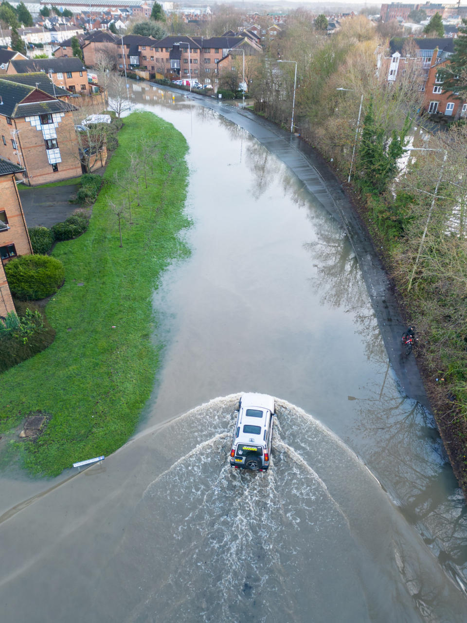 A vehicle makes its way through flooded roads in Loughborough, Leicestershire. (SWNS)