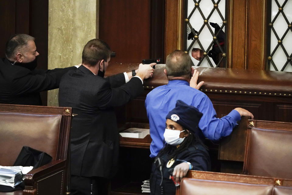 Image: Police with guns drawn watch as protesters try to break into the House Chamber. (J. Scott Applewhite / AP file)
