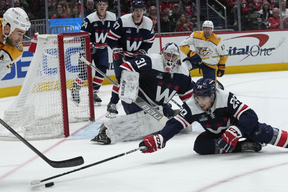Washington Capitals goaltender Hunter Shepard (31) watches as his teammate Washington Capitals center Hendrix Lapierre (29) tries to get the puck from Nashville Predators center Ryan O'Reilly (90) during the second period of an NHL hockey game in Washington, Saturday, Dec. 30, 2023. (AP Photo/Susan Walsh)