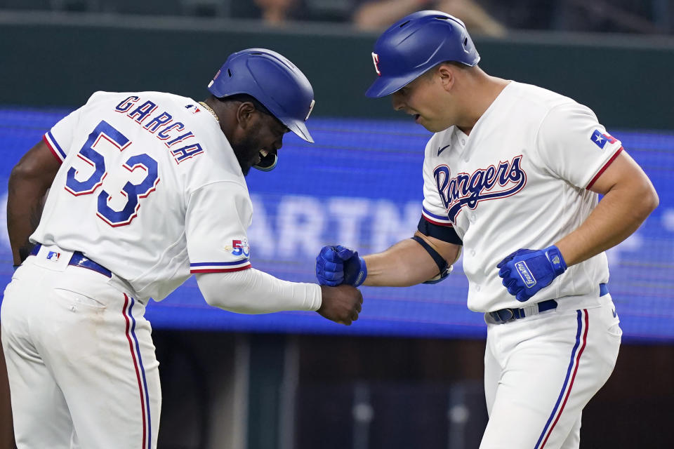 Texas Rangers' Nathaniel Lowe, right, celebrates his two run home run with Adolis Garcia (53) after they scored during the fourth inning of the team's baseball game against the Houston Astros in Arlington, Texas, Tuesday, June 14, 2022. (AP Photo/LM Otero)