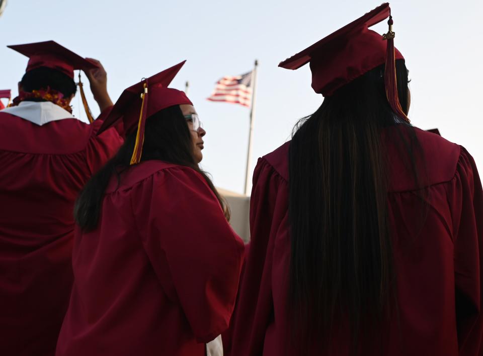 A US flag flies above a building as students earning degrees at Pasadena City College participate in the graduation ceremony, June 14, 2019, in Pasadena, California. - With 45 million borrowers owing $1.5 trillion, the student debt crisis in the United States has exploded in recent years and has become a key electoral issue in the run-up to the 2020 presidential elections. "Somebody who graduates from a public university this year is expected to have over $35,000 in student loan debt on average," said Cody Hounanian, program director of Student Debt Crisis, a California NGO that assists students and is fighting for reforms. (Photo by Robyn Beck / AFP)        (Photo credit should read ROBYN BECK/AFP/Getty Images)