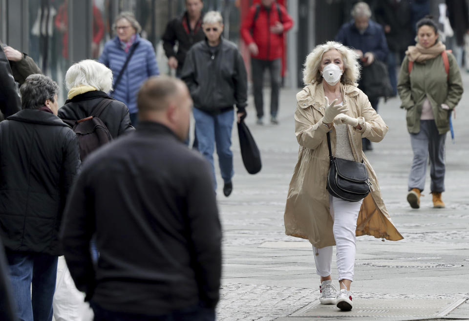 Pepole walk on a shopping road in Berlin, Germany, Thursday, March 19, 2020. Due to the coronavirus outbreak German authorities ask people to avoid large crowds of people. For most people, the new coronavirus causes only mild or moderate symptoms. For some it can cause more severe illness. (AP Photo/Michael Sohn)