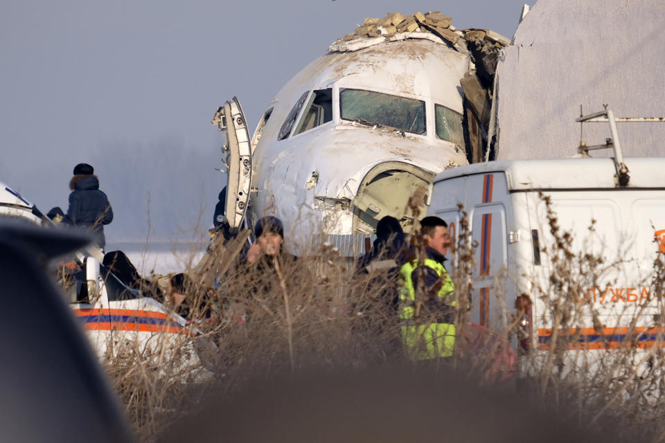 Police stand guard as rescuers assist on the site of a plane crashed near Almaty International Airport, outside Almaty, Kazakhstan, Friday, Dec. 27, 2019. The Kazakhstan plane with 98 people aboard crashed shortly after takeoff early Friday. (AP Photo/Vladimir Tretyakov)