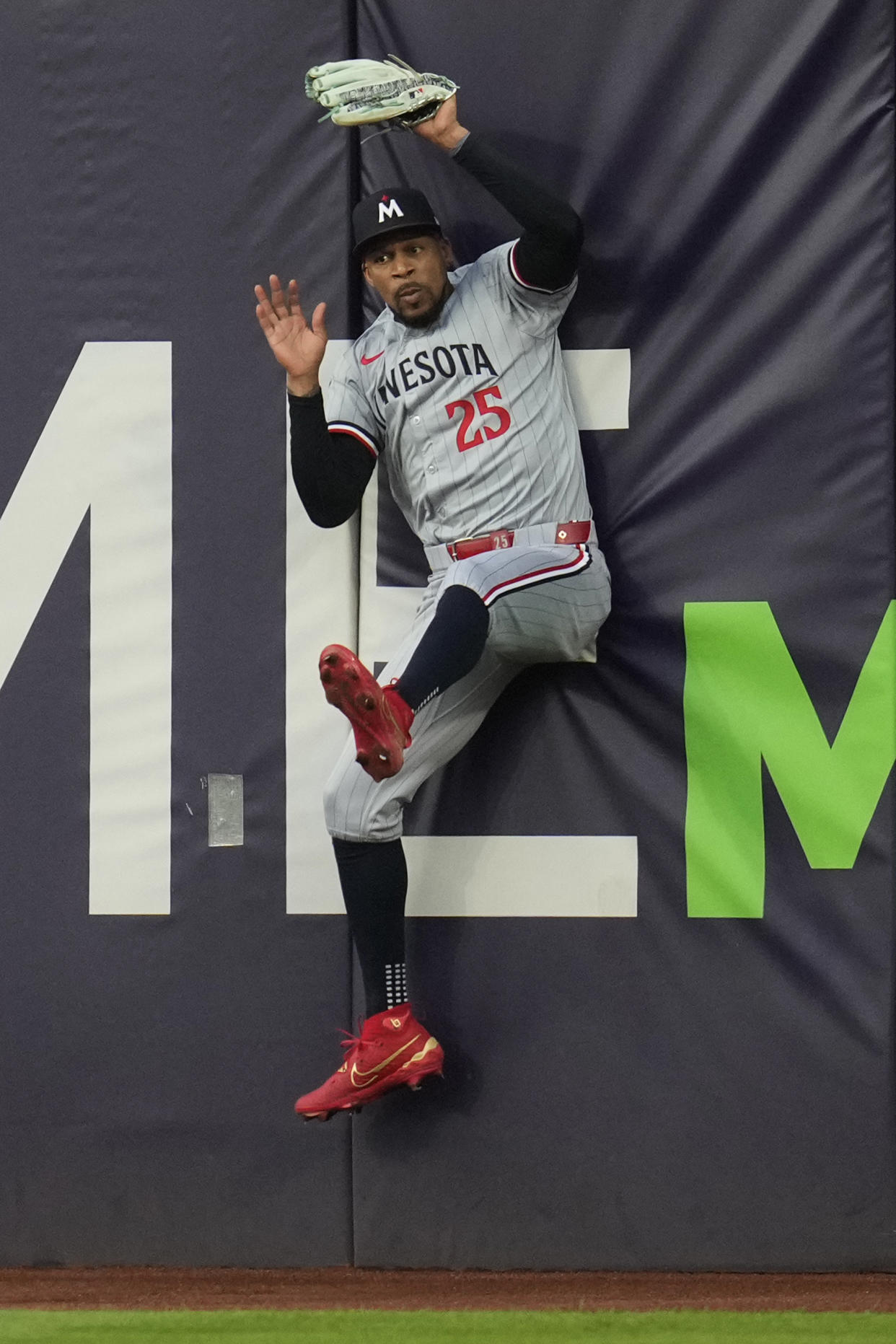 Minnesota Twins center fielder Byron Buxton crashes into the outfield padding after catching a fly ball for an out against Cleveland Guardians' Bo Naylor in the second inning of a baseball game Monday, Sept. 16, 2024, in Cleveland. (AP Photo/Sue Ogrocki)