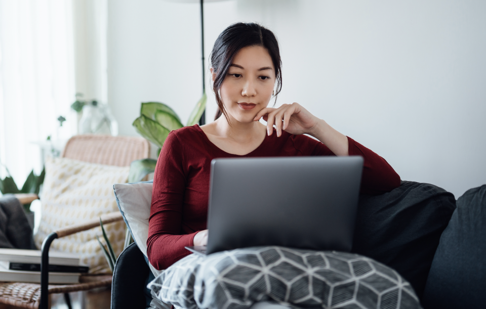 a woman sitting on a couch with a laptop