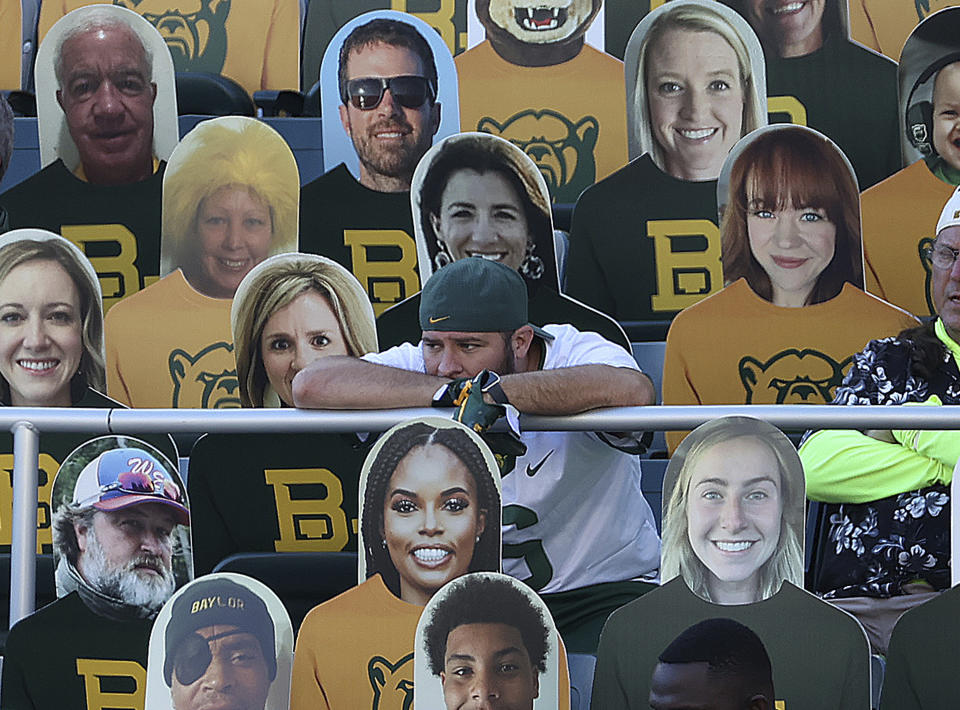 A fan watches an NCAA college football game between TCU and Baylor while seated next to cutouts in Waco, Texas, Saturday, Oct. 31, 2020. (Jerry Larson/Waco Tribune-Herald via AP)