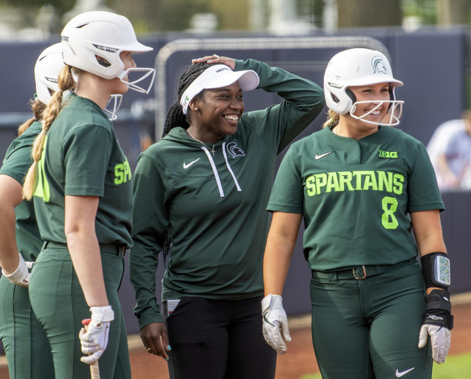 Michigan State coach Sharonda McDonald-Kelley laughs with some of her players, including outfielder Brooke Snyder (8), during the team's NCAA college softball game against Illinois on Friday, April 21, 2023, in Urbana, Ill. (Robin Scholz/The News-Gazette via AP)