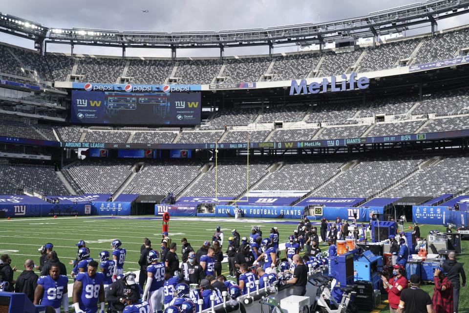 An empty MetLife stadium with the Giants on the sidelines. 