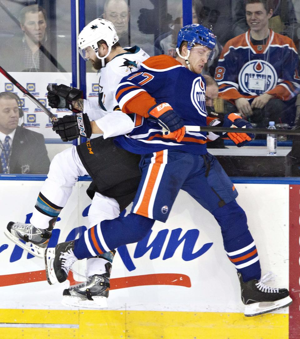 San Jose Sharks' Brent Burns (88) is checked by Edmonton Oilers' Anton Belov (77) during the second period of an NHL hockey game Wednesday, Jan. 29, 2014, in Edmonton, Alberta. (AP Photo/The Canadian Press, Jason Franson)