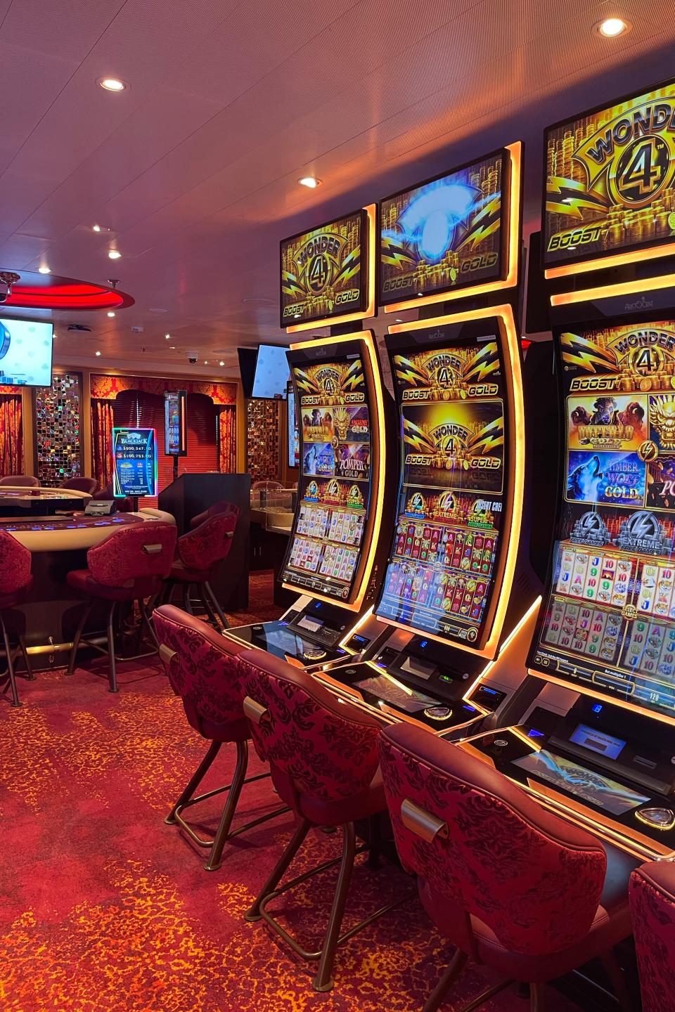 Slot machines in a casino with screen displaying game options like 'Wild Lepre'coins', 'Buffalo Gold', and 'Pompeii'