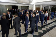 Lebanese lawmakers and ministers wait in the foyer due to a power outage for a meeting to confirm Lebanon's new government, at a theater known as the UNESCO palace so that parliament members could observe social distancing measures imposed over the coronavirus pandemic, in Beirut, Lebanon, Monday, Sept. 20, 2021. Electricity later came back 40 minutes later and the meeting was held. (AP Photo/Bilal Hussein)