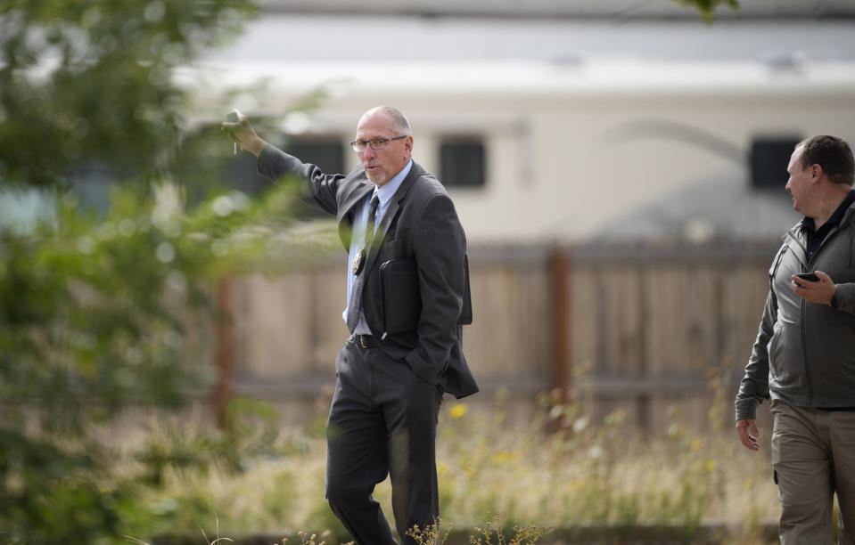 FILE - Fremont County, Colo., coroner Randy Keller meets with fellow authorities outside a closed funeral home where 115 bodies have been stored, Friday, Oct. 6, 2023, in Penrose, Colo. The owner of the funeral home and his wife were arrested Wednesday, Nov. 8, after the decaying remains of at least 189 people were recently found at his facility. Jon and Carrie Hallford were arrested in Wagoner, Oklahoma, on suspicion of four felonies: abuse of a corpse, theft, money laundering and forgery, District Attorney Michael Allen said in a news release after at least some of the aggrieved families were told. (AP Photo/David Zalubowski, File)