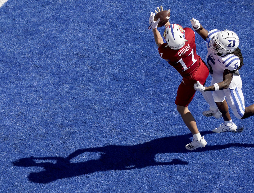 Kansas wide receiver Luke Grimm (11) catches a pass under pressure from Duke defensive back Datrone Young (5) to score a touchdown during the first half of an NCAA college football game Saturday, Sept. 24, 2022, in Lawrence, Kan. (AP Photo/Charlie Riedel)