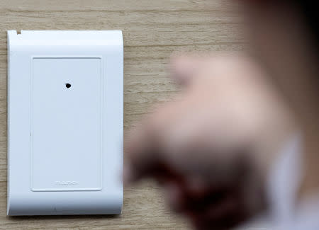 A police officer demonstrate a subminiature spycam installed inside a wall which is used to film guests illicitly at a motel, in Seoul, South Korea, March 20, 2019. Picture taken on March 20, 2019. Yonhap via REUTERS