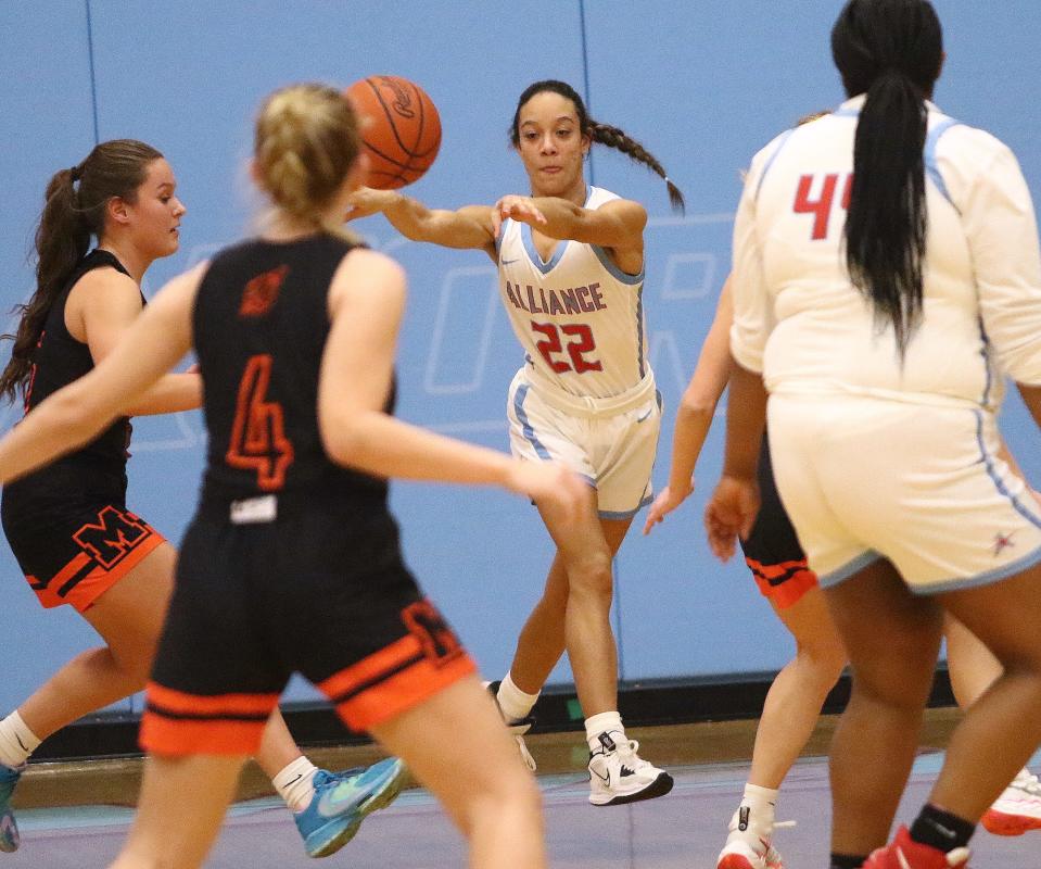 Alliance's Payton Smith (22) passes the ball between Marlington defenders during action at Alliance High School Wednesday night, February 1, 2023.