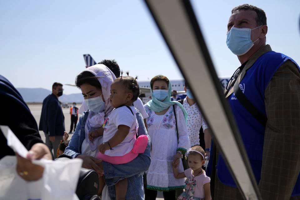 Afghan refugees wearing face masks to prevent the spread of the coronavirus, board an airplane bound for Portugal at the Eleftherios Venizelos International Airport in Athens, on Tuesday, Sept. 28, 2021. The 41 refugees from Afghanistan were relocated as part of a migrant reunification plan agreed between the two countries. (AP Photo/Thanassis Stavrakis)