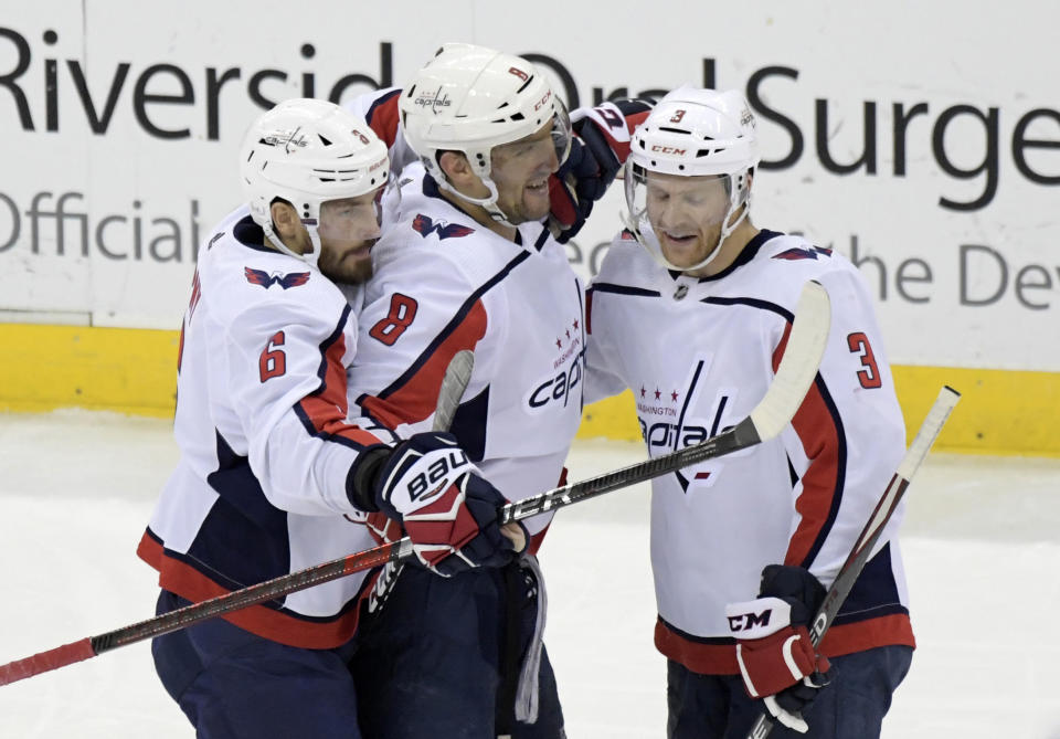 Washington Capitals left wing Alex Ovechkin (8) celebrates his 700th career goal with defenseman Michal Kempny (6) and defenseman Nick Jensen (3) during the third period of an NHL hockey game against the New Jersey Devils Saturday, Feb. 22, 2020, in Newark, N.J. (AP Photo/Bill Kostroun)