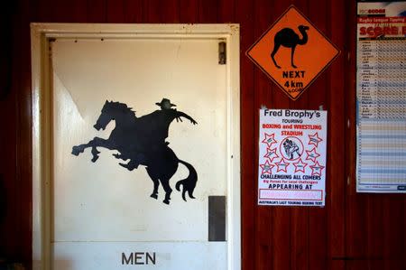 Posters adorn the wall next to the door for the men's toilet at the Stonehenge Pub, located in outback Queensland in Australia, August 13, 2017. REUTERS/David Gray