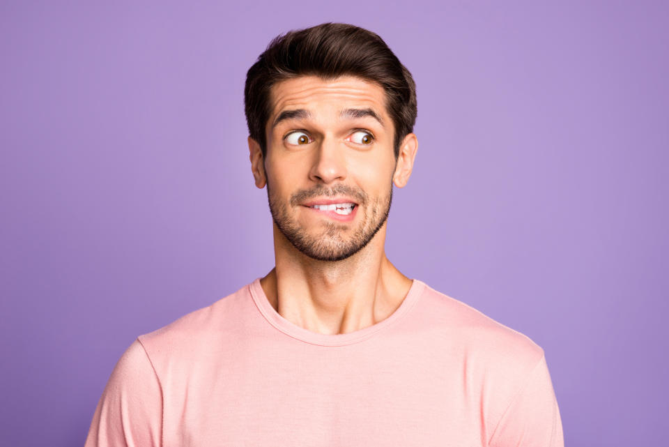 Man in pink shirt making a puzzled expression