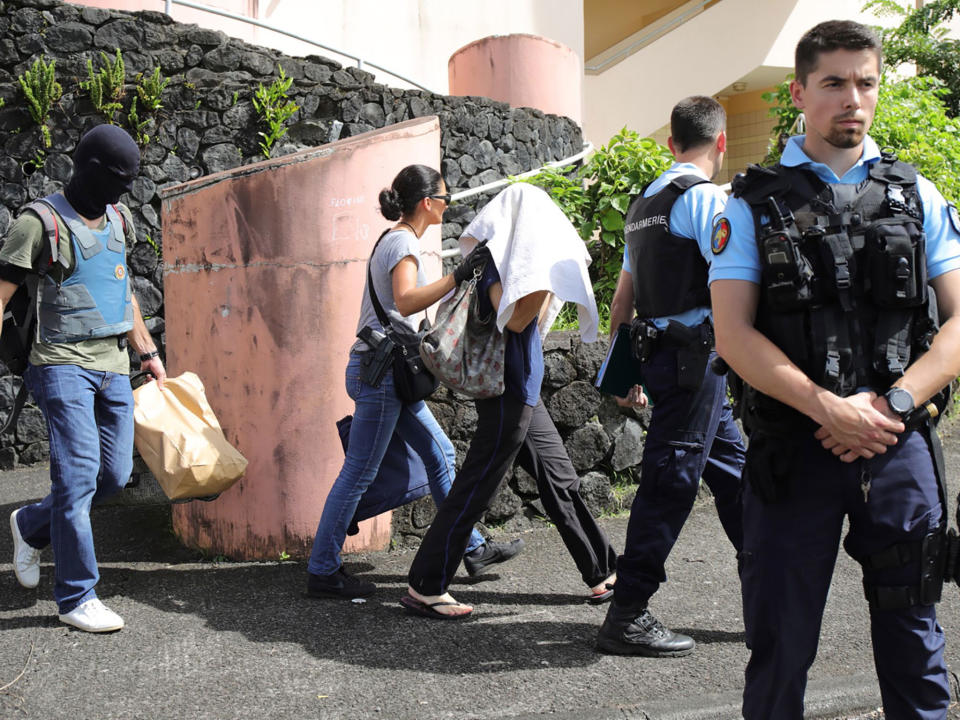 French gendarmes and police officers escort a person on the French island of Reunion, after a man suspected of being a radicalised Islamist shot two officers on 27 April: AFP/Getty