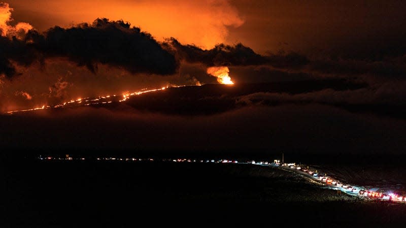 A line of vehicles heading towards a lava flow