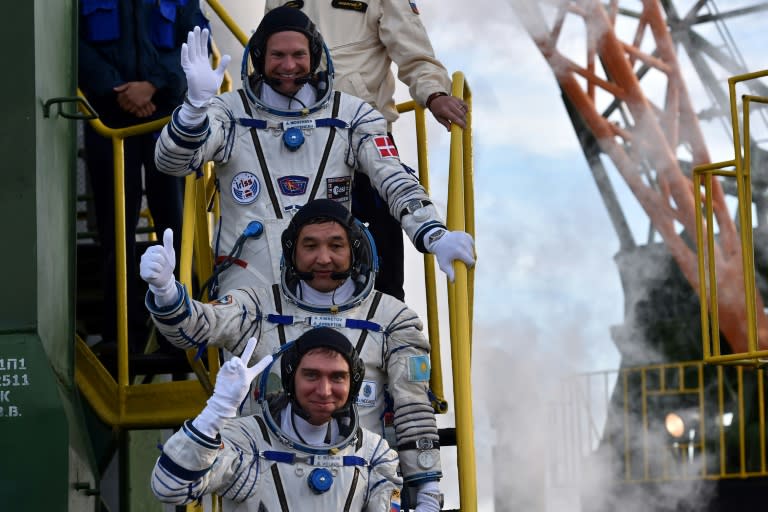 Kazakhstan cosmonaut Aydyn Aimbetov (C), Russian cosmonaut Sergei Volkov and Danish astronaut Andreas Mogensen (top) wave as they board the Soyuz TMA-18M spacecraft on September 2, 2015