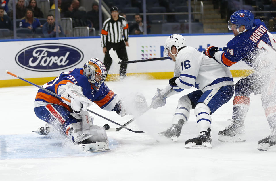 New York Islanders goalie Ilya Sorokin makes a save on Toronto Maple Leafs forward Mitchell Marner (16) as Islanders center Bo Horvat defends during the first period of an NHL hockey game, Monday, Dec. 11, 2023, in New York. (AP Photo/John Munson)