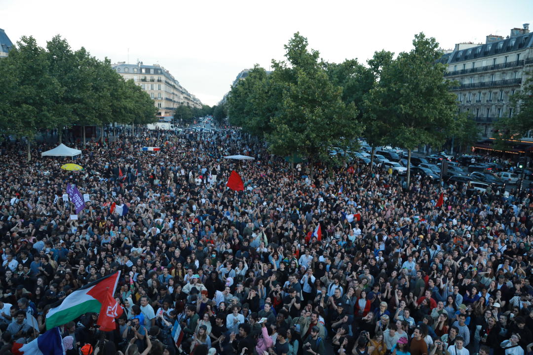 PARIS, FRANCE - JULY 07: People, holding flags and banners, gather at the Republique Square following the second round results of France's legislative election in Paris, France on July 07, 2024. France's left-wing New Popular Front alliance leads in Sunday's snap parliamentary elections, seemingly halting the rise of far-right, polls said. The NFP could win 180 to 215 seats in the parliament's lower chamber, the National Assembly, according to projections based on the surveying company Ifop's estimations. The centrist alliance, Together for the Republic, backed by President Emmanuel Macron ranked second with 150 to 180 seats, while Marine Le Pen's far-right National Rally (RN), which celebrated its victory in the first round, will get 120 to 150 seats. (Photo by Mohamad Salaheldin Abdelg Alsayed/Anadolu via Getty Images)