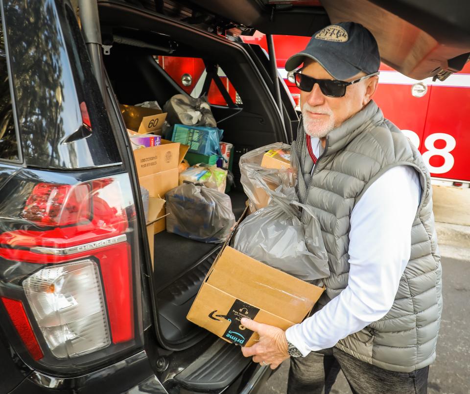 Wally Wagoner, a board member of Interfaith Emergency Services, helps unload food from an SUV on Friday. He was among the volunteers who helped with the annual Bring the Harvest Home food drive.