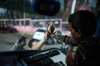 <p>A boy says goodbye to a friend through the windshield of a bus that will carry him to Mexico City from the sports club where Central American migrants traveling with the annual “Stations of the Cross” caravan had been camping out in Matias Romero, Oaxaca State, Mexico, Thursday, April 5, 2018. (Photo: Felix Marquez/AP) </p>