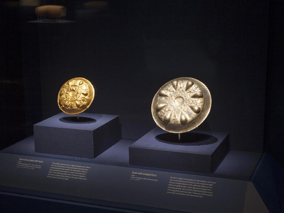 In this image provided by The Smithsonian Institution, a gold bowl from the Oxus Treasure, left, and a silver bowl with winged lions and heads of the Egyptian deity Bes are seen on display at the Smithsonian's Freer Sackler Gallery in Washington. The items go with a exhibit along with the Cyrus Cylinder, a 2,500-year-old Babylonian artifact sometimes described as the world's first human rights charter will be shown for the first time in the United States, beginning with the Smithsonian’s Freer Sackler Gallery, followed by stops in New York, Houston and Los Angeles. The British Museum is loaning the Cyrus Cylinder, which carries an account of how Persian king Cyrus conquered Babylon in 539 B.C. and restored people held captive to their homelands. (AP Photo/The Smithsonian Institution, John Tsantes)