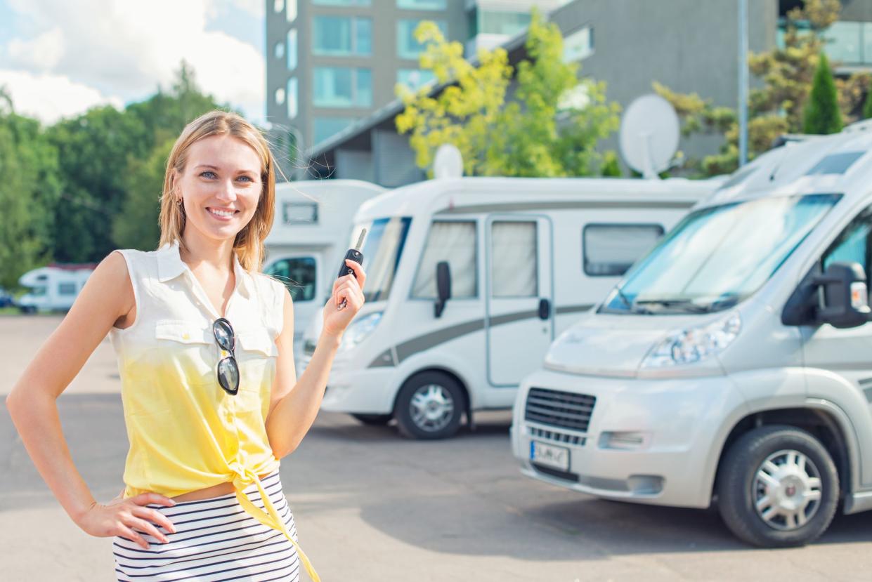 Beautiful young woman offers campervans at shop.