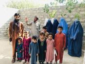 Mohammed Jafar poses for a picture along with widows of his three brothers, their children and his father, in Kunar