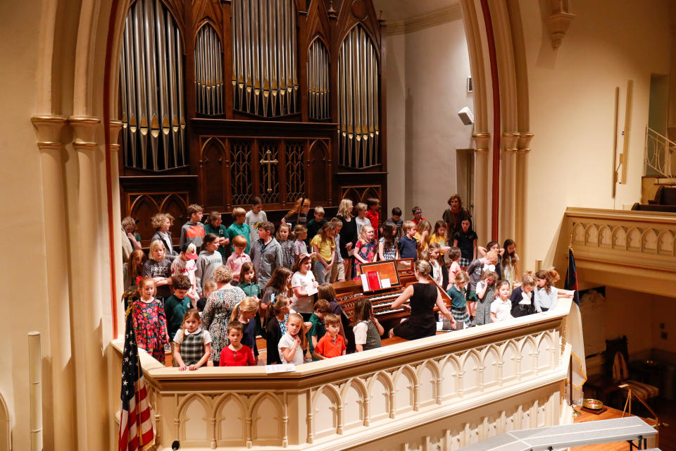 62 1st-5th grade students gather in the choir loft around the organ as they rehearse for the Children of the Light concert at Wesley Monumental UMC.