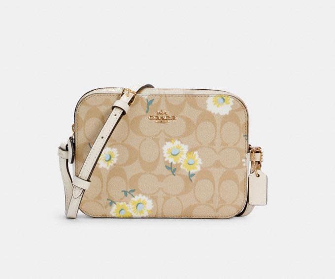 Mini Camera Bag In Signature Canvas With Daisy Print. Image via Coach Outlet.