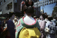 <p>Geisha girls prepare to parade down the streets toward Asakusa Shrine in the compound of Sensoji Temple, May 19, 2017, in Tokyo prior to the annual Sanja Festival, one of the city’s three major festivals. (Photo: Eugene Hoshiko/AP) </p>