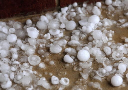 Hail stones of varying sizes collect on the front porch of a Midwest City home after a severe storm hit areas of eastern Oklahoma County.