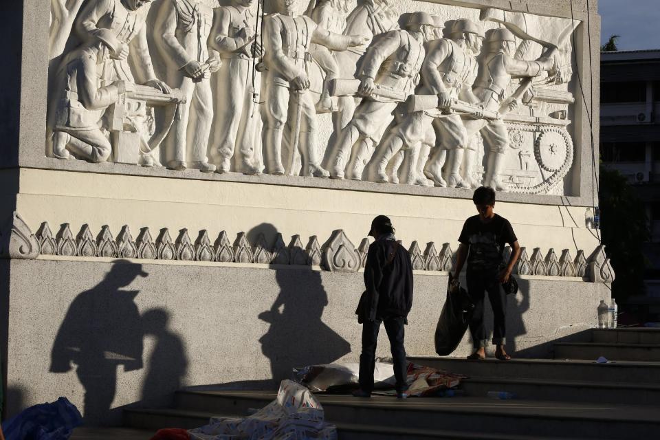 Volunteers from anti-government protesters clean up after an overnight shooting attack at Democracy Monument in Bangkok, Thailand, Thursday, May 15, 2014. Explosions and the overnight shooting attack on opposition demonstrators in Thailand’s capital killed at least two people Thursday, the latest violence to hit Bangkok since protesters launched a campaign to oust the government six months ago. (AP Photo/Vincent Thian)